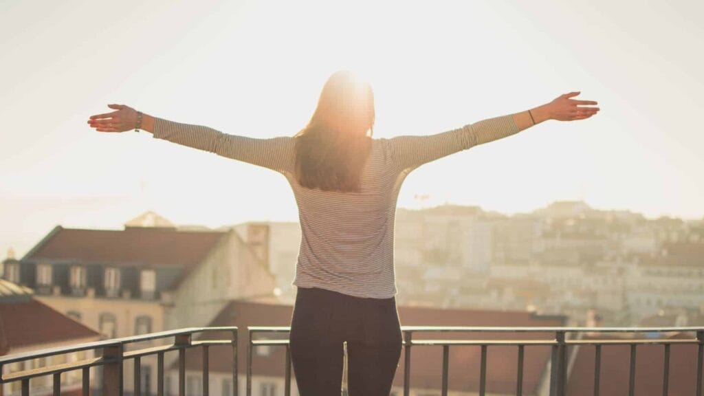Woman enjoying sunrise on balcony