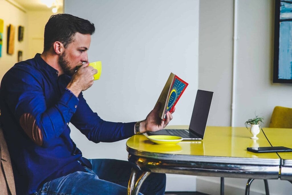 Man reading book with coffee at table