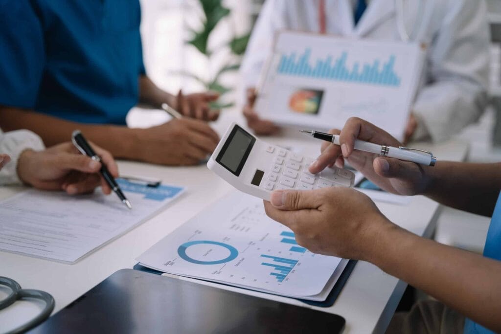 A group of doctors at a table discussing hospital billing and charges.