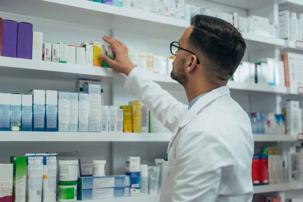 Pharmacist organizing shelves of medication