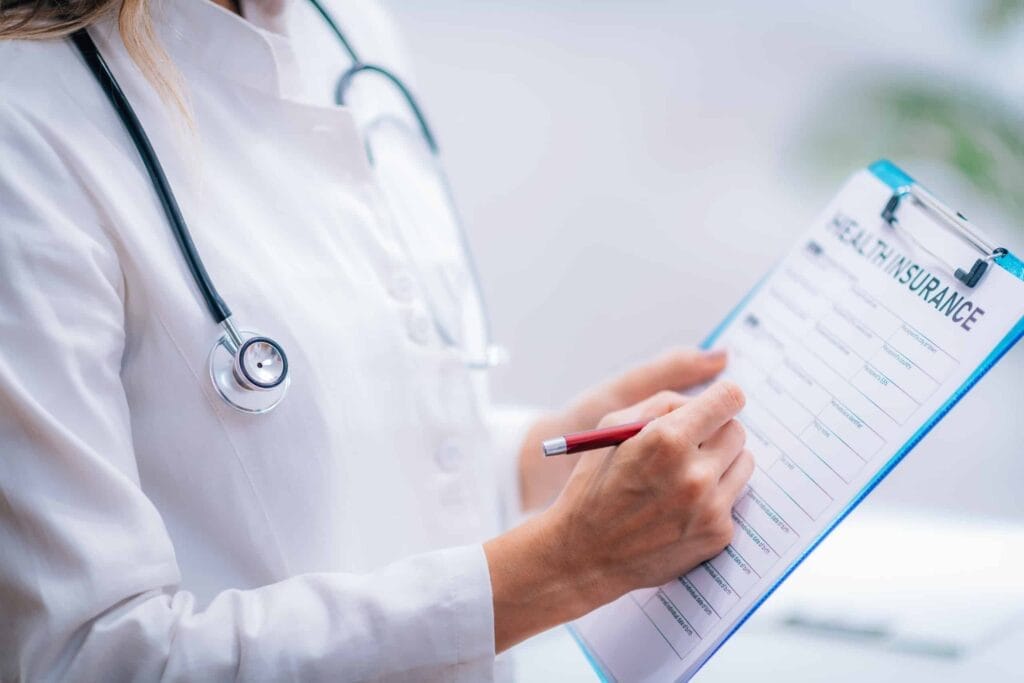 A female doctor writing on a clipboard while discussing Special Open Enrollment, encouraging small employers to provide coverage for eligible employees.