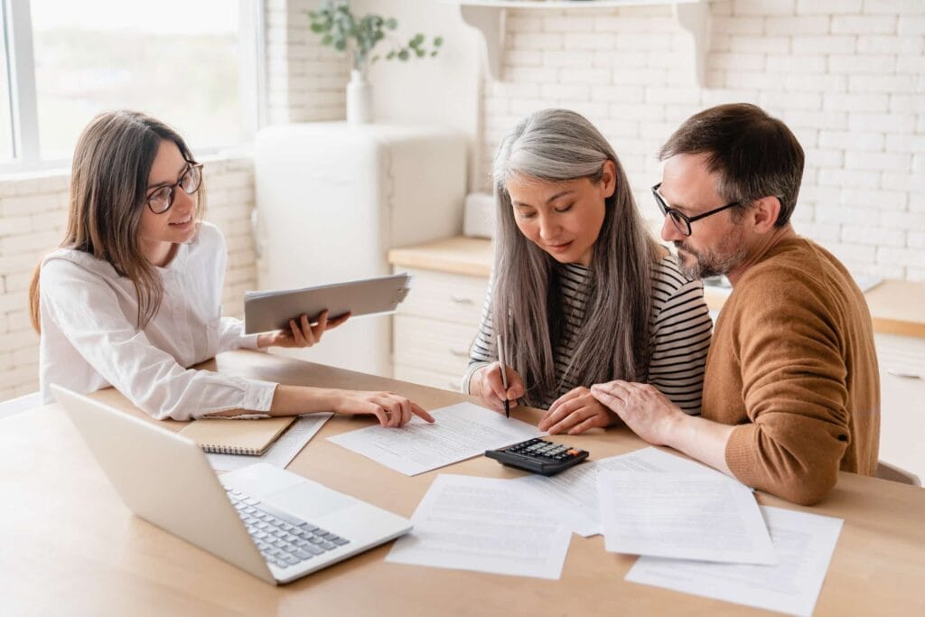 A group of people sitting at a table, discussing and evaluating paperwork with a Third Party Administrator (TPA).