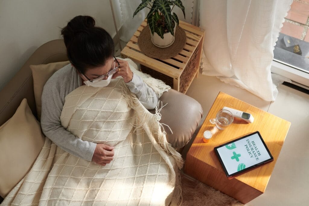 A woman is sitting on a couch with a tablet, discussing the importance of long-term care over life insurance.