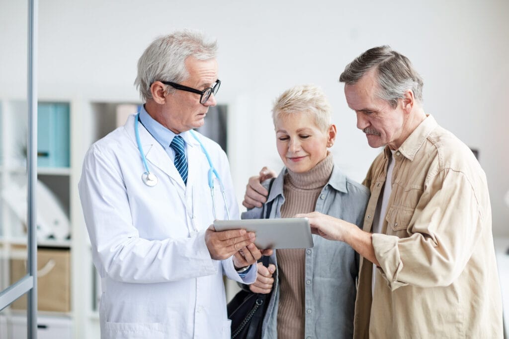 A group of people examining a tablet while a doctor highlights key points of the Affordable Care Act.