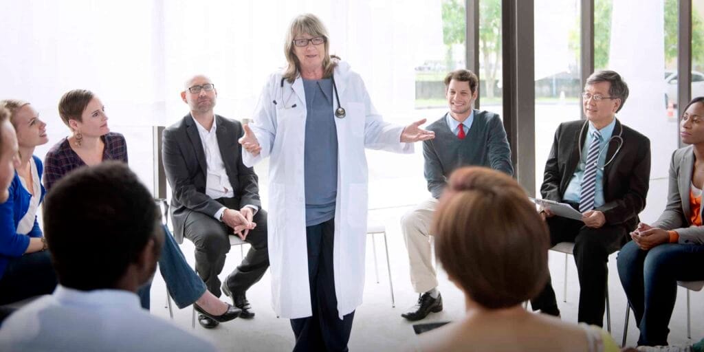Doctor leads discussion with group of professionals.