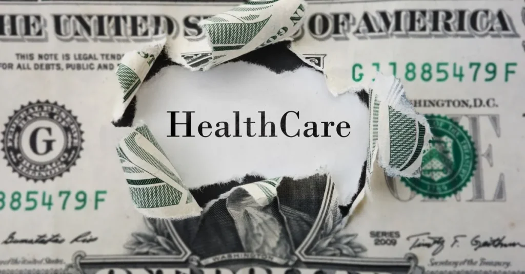 Burning dollar revealing the word health insurance, symbolizing rising healthcare costs for small businesses.